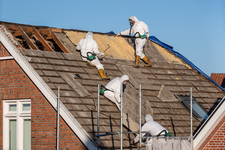 Professionals In Protective Suits Remove Asbestos-cement Roofing Professionals in protective suits remove asbestos-cement roofing underlayment